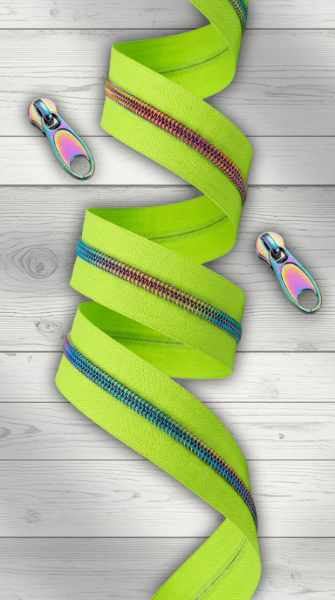 imettengrüner Endlosreißverschluss als Meterware mit irisierender Regenbogenraupe, aufgerollt auf hellem Holzhintergrund, zwei lose Zipper daneben.