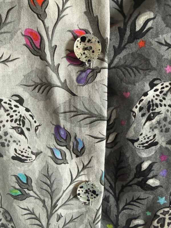 Nahaufnahme der Knöpfe der Alea-Bluse – weiß mit schwarzen, unregelmäßigen Punkten, passend zum Leopardenprint des Tula Pink Graywork Stoffs