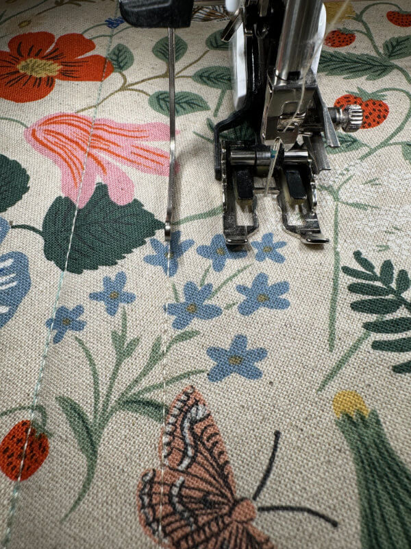 Walking Foot quiltet gerade Linien auf hellem Leinenstoff mit Blumenmuster