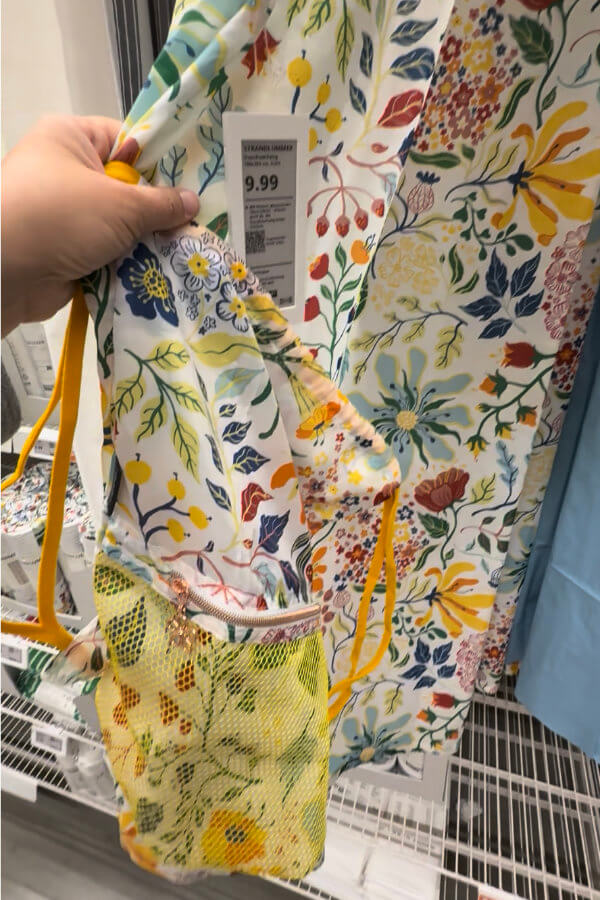 Geblümter IKEA-Duschvorhang im Laden, davor ein daraus genähter Rucksackbeutel mit Netztasche