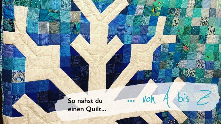Selbstgenähter Patchwork-Quilt in Blautönen als Titelbild der Anleitung für den ersten Quilt