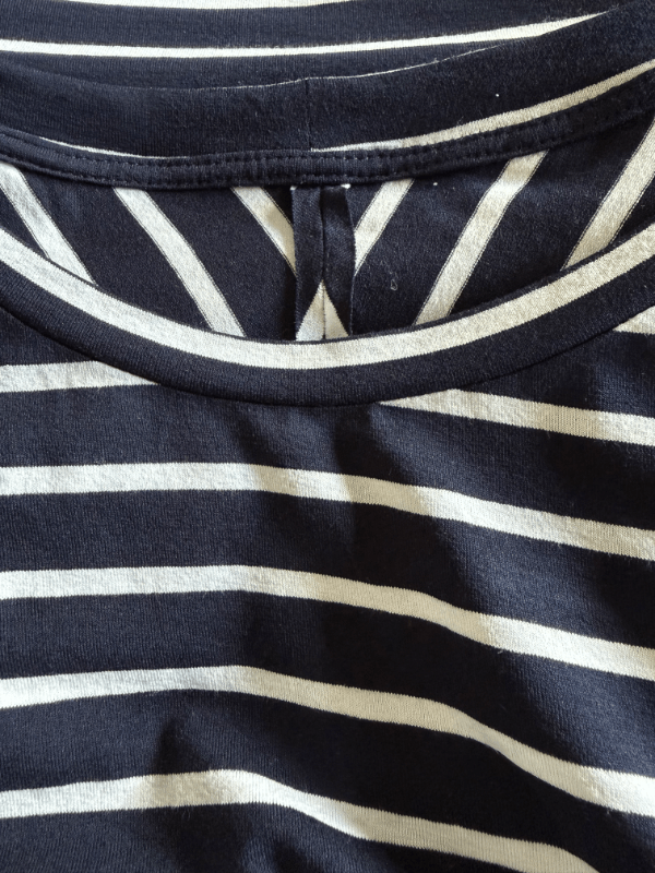 Detailaufnahme vom Halsausschnitt eines dunkelblau-weißen Ringelshirts mit Streberstreifen am Halsausschnitt