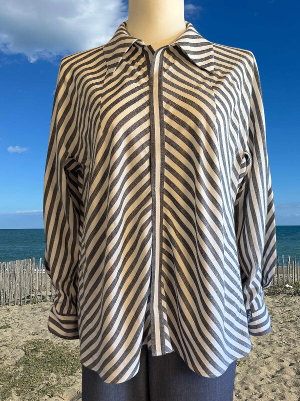 Gestreifte Bluse aus Leinen-Viskose ohne Schulternähte auf einer Schneiderpuppe am Strand, Vorderansicht