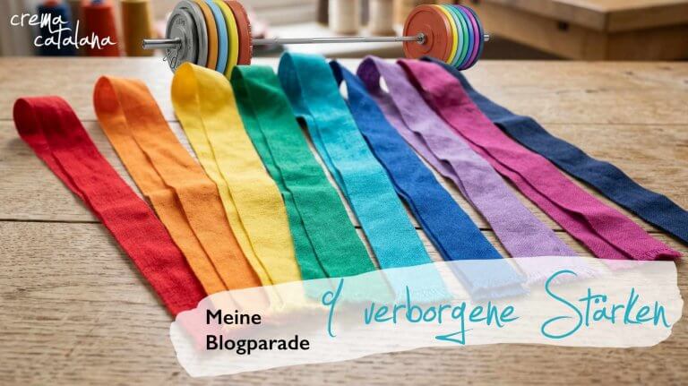 Neun Textilstreifen in verschiedenen Farben, und eine Hantelstange im Hintergrund, Sinnbild für neun Beiträge zur Blogparade