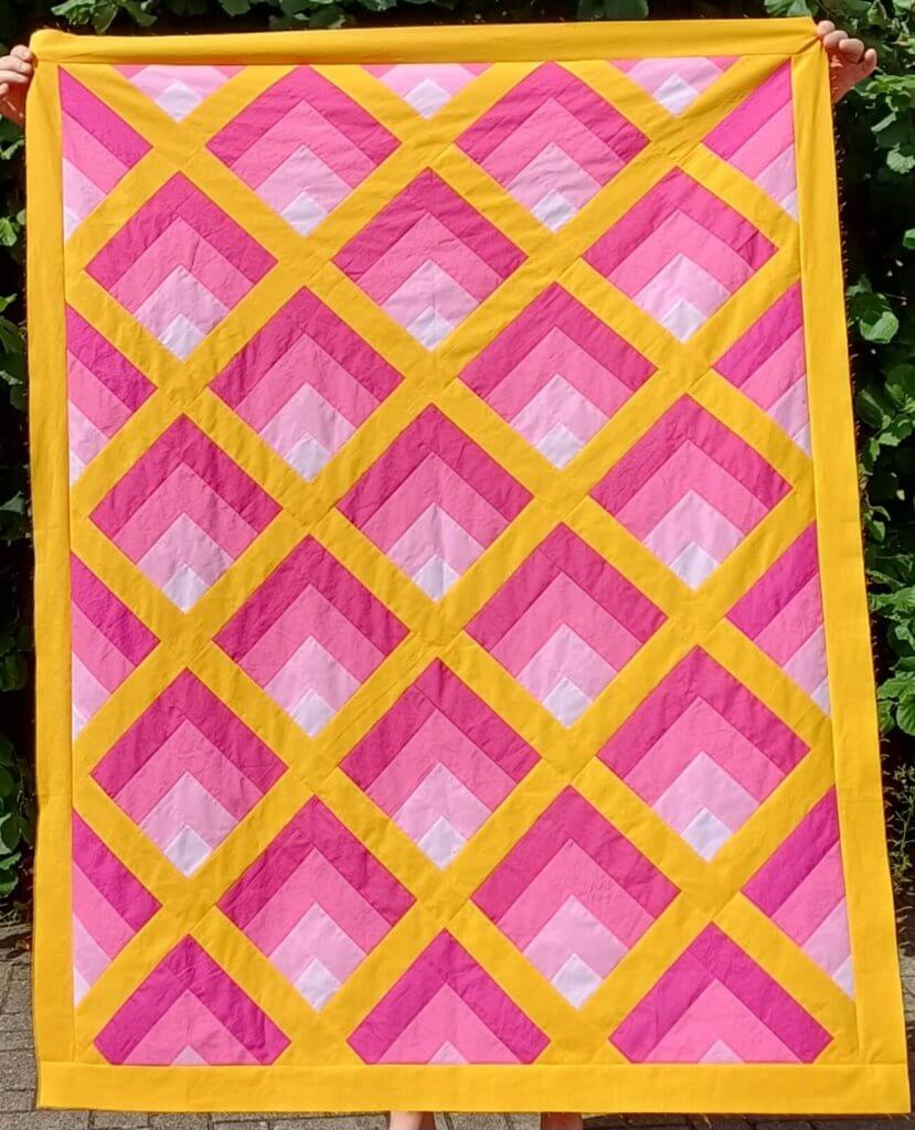 Lichtspiel-Quilt in Pink und Gelb, on-point gesetzt, in Babygröße